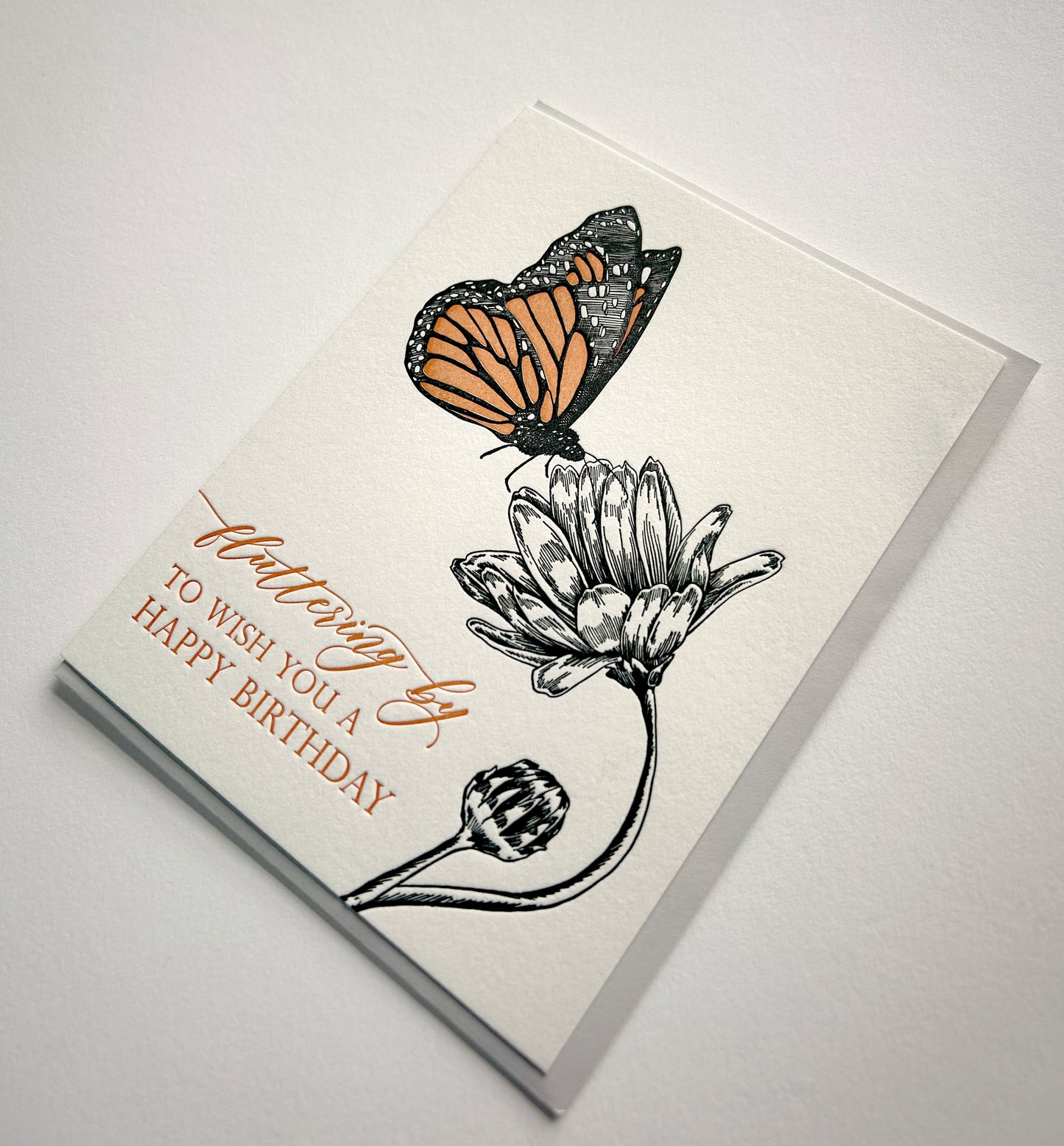 Letterpress birthday card with a butterfly and flower that says " Fluttering by to wish you a happy birthday" by Rust Belt Love