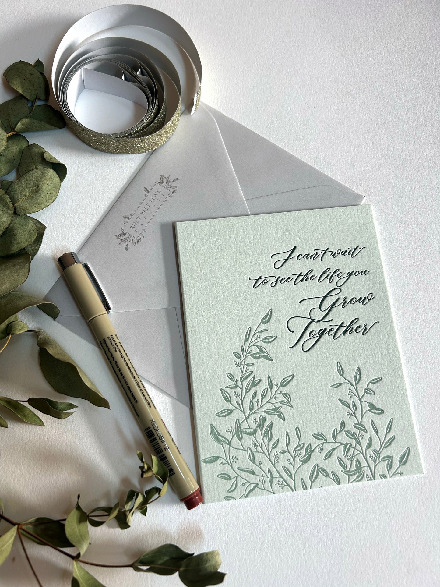 Style shot of letterpress wedding card that reads "I can't wait to see the life you grow together" by Rust Belt Love
