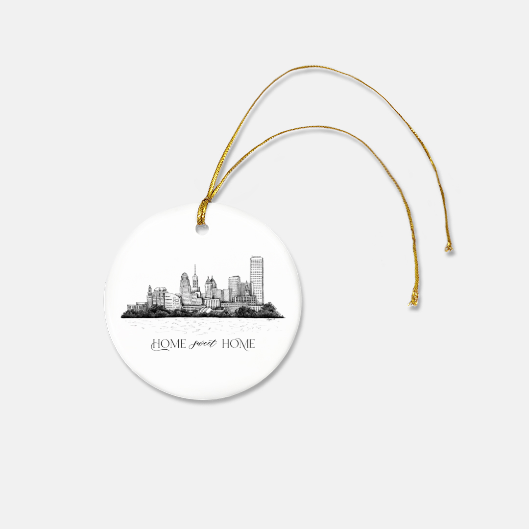Round frosted glass ornament with the buffalo skyline on it that says "home sweet home" with a gold ribbon by Rust Belt Love