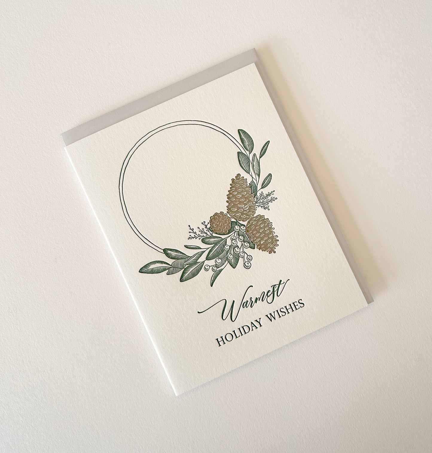 Letterpress holiday card with pinecones and greenery that says "Warmest holiday wishes" by Rust Belt Love