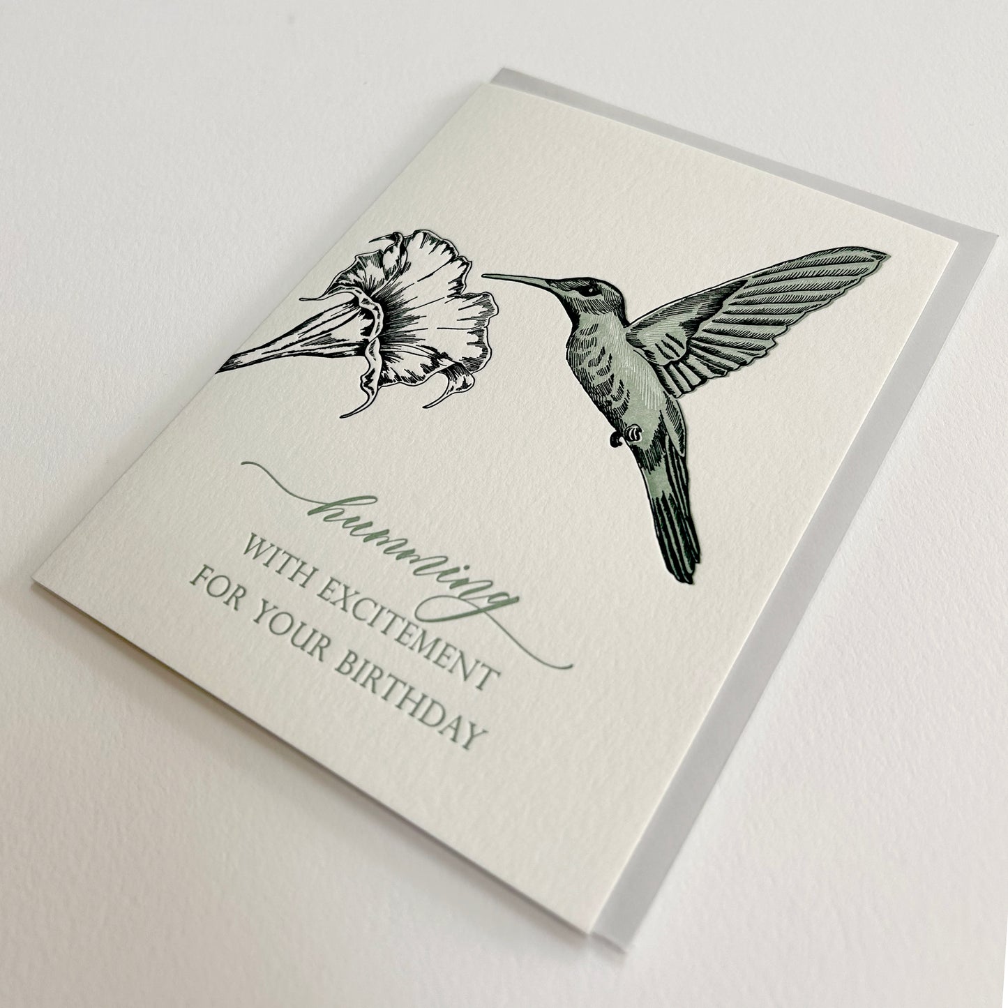 Letterpress birthday card with a flower and hummingbird that reads "Humming with excitement for your birthday" by Rust Belt Love