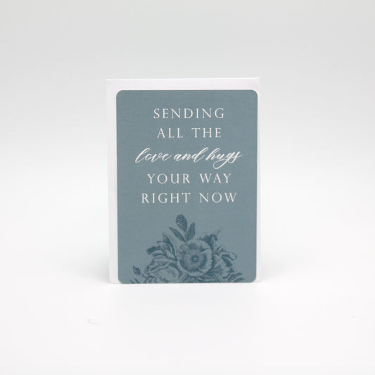 Light blue floral minicard that reads "Sending all the love and hugs your way right now" by Rust Belt Love