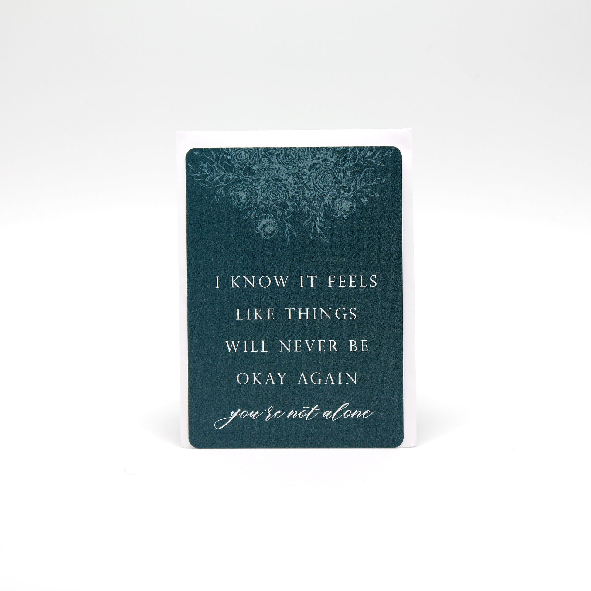 Dark teal floral minicard that reads "i now it feels like things will never be okay again you're not alone" by Rust Belt Love
