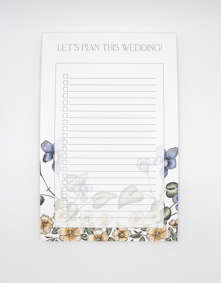 5.5 by 8.5 notepad with lined sheets with multi-colored florals that says "Let's plan this wedding!" by Rust Belt Love