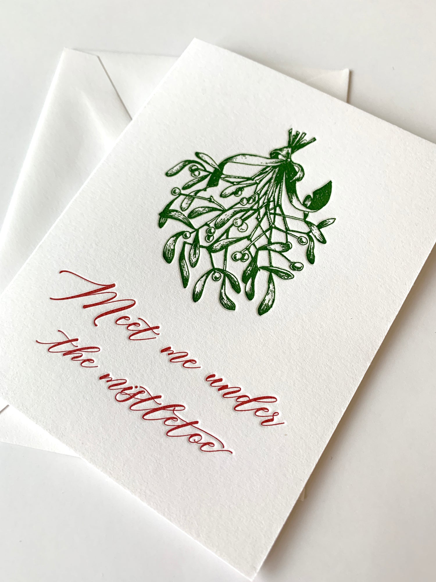 Letterpress holiday card with mistletoe that says "Meet me under the mistletoe" by Rust Belt Love