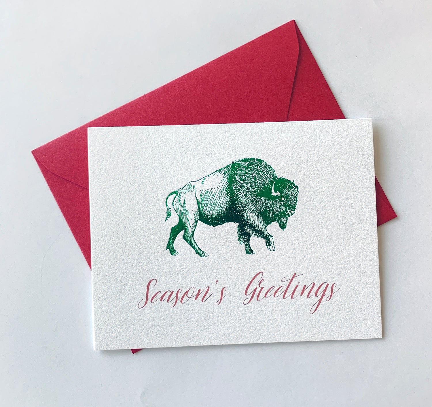 Letterpress holiday card with green foil buffalo that says "Season's greetings" by Rust Belt Love