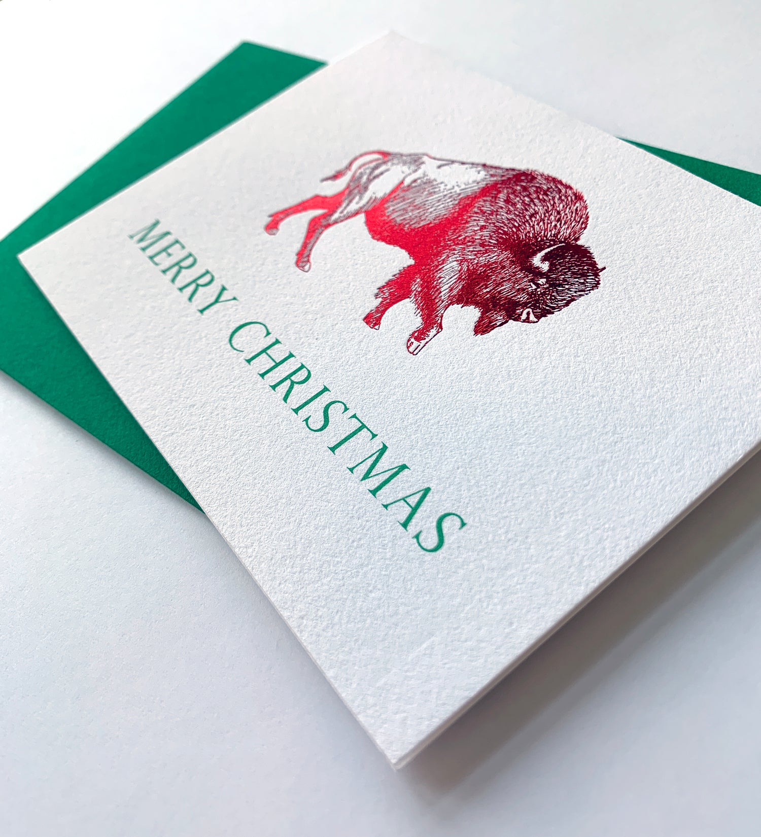 Letterpress holiday card with red foil buffalo that says "Merry Christmas" by Rust Belt Love