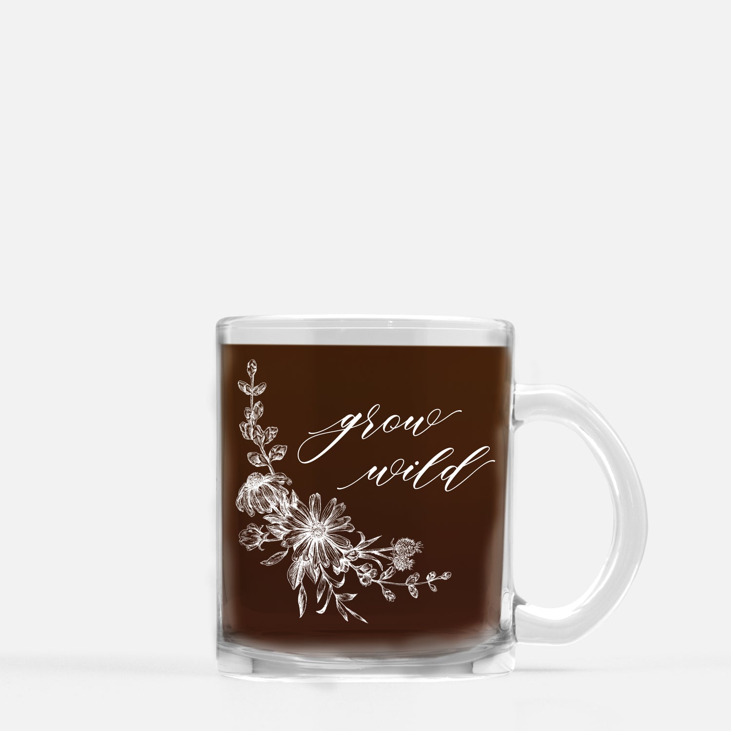 White ink on clear glass mug with flowers and that says grow wild